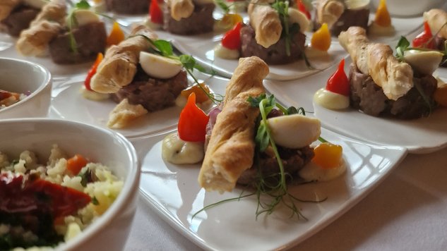 Honig auf frisch gebackenem Brot Herzhaftes Beef Tartare mit Blätteteigstangerl und Wachtelei